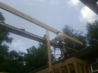 Carpenter setting a ridge beam over a new addition frame — Ice Dam Removal by Roofing Brothers in Bakerstown
