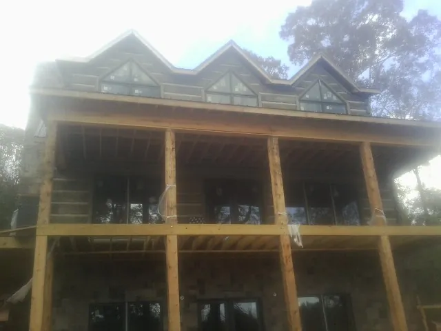 Dormers and porch framing on a large log home under construction — Roof Coating work by our crew in Bakerstown