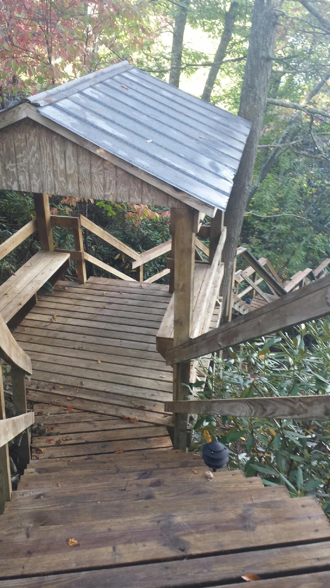 Metal roofed shelter over wooden steps on a wooded walkway — Skylight Repair & Installation work by our crew in Bakerstown