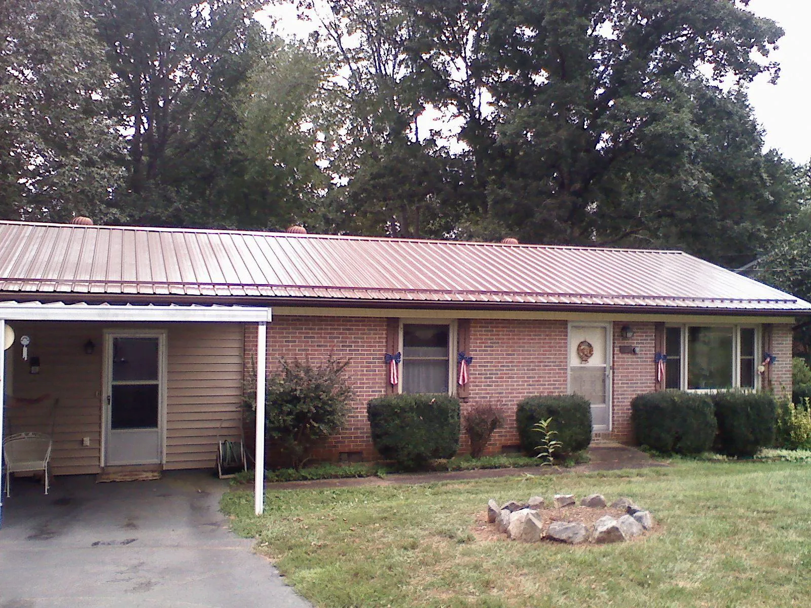 Bronze metal roof and carport on a brick ranch home — Roof Repair work by our crew in Bakerstown